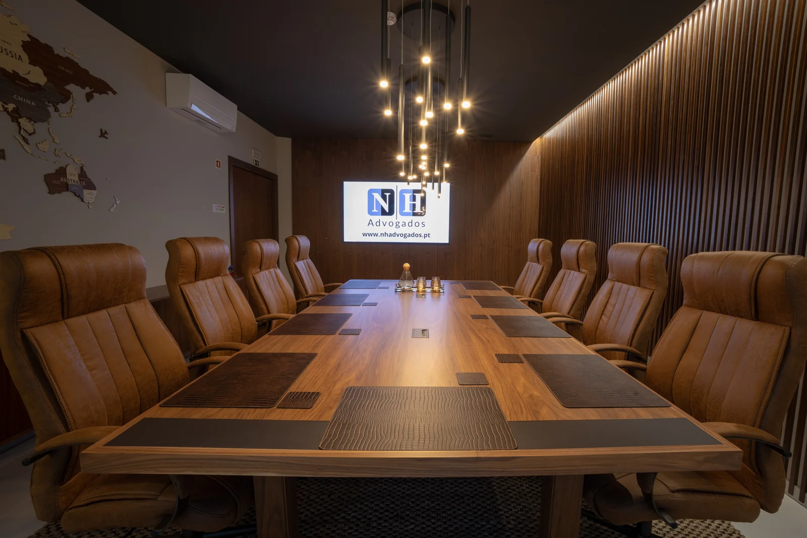 Sala de reuniões do escritório, com mesa e painéis em madeira